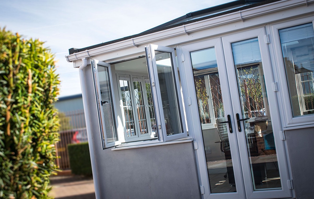 Exterior view of an open white uPVC French casement window showing a clear, unobstructed wide opening without a central pillar.