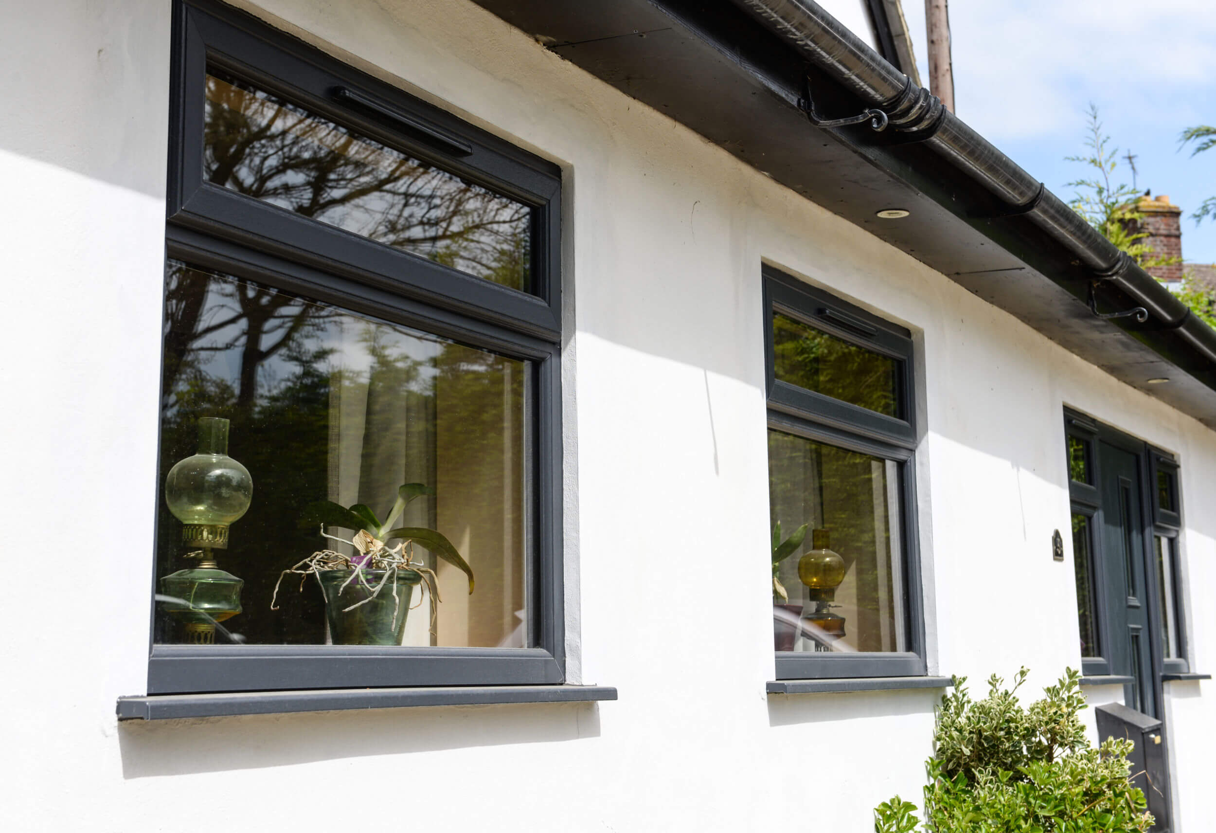Close-up of a Profile22 Optima sculptured uPVC window frame in anthracite grey installed against a white rendered exterior wall.
